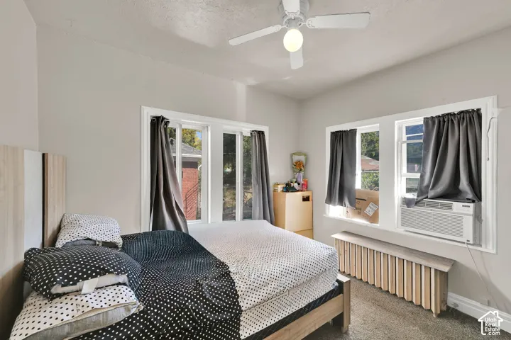 Recessed lighting, ceiling fan fixture, window unit air conditioner, light-toned wall paint, and exposed window framing