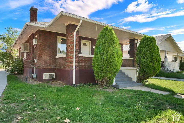 Brick exterior with white trim, covered porch, and concrete steps