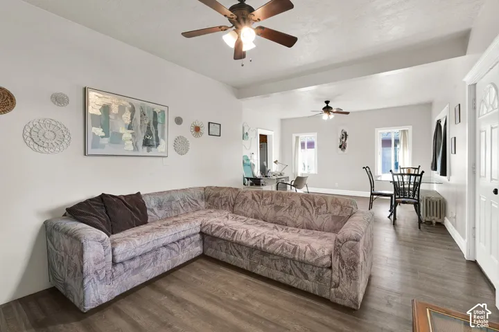 Spacious living area featuring a sectional layout with wood-finish flooring throughout