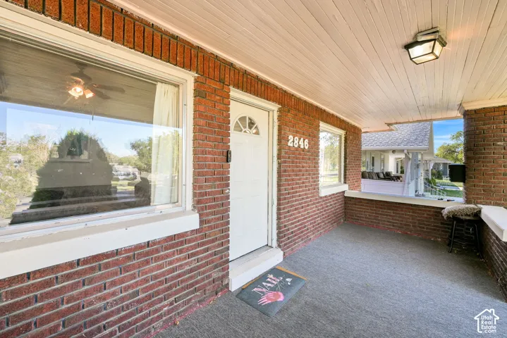 Brick exterior featuring a covered porch with a paneled ceiling and recessed lighting