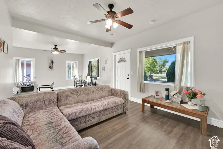 Open-concept living space featuring wood-finish flooring, recessed lighting, and multiple windows for natural light