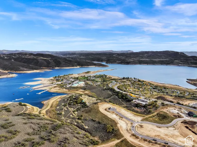 Expansive lakefront setting with surrounding mountainous terrain, featuring a marina, developed shoreline, and paved access roads