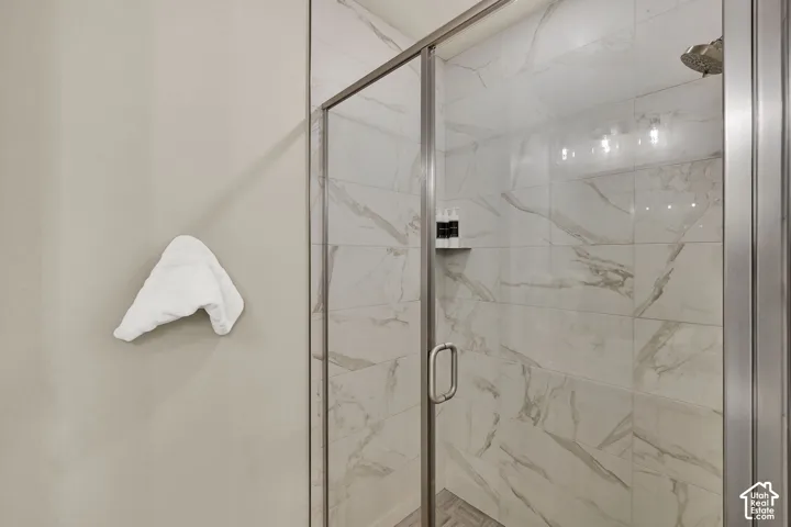 Glass-enclosed shower with tile surround and showerhead