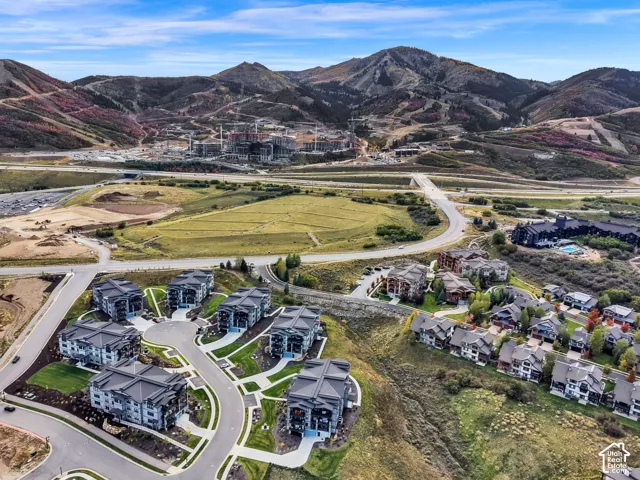 Mountain backdrop featuring multiple residential buildings, paved roadways, and landscaped grounds
