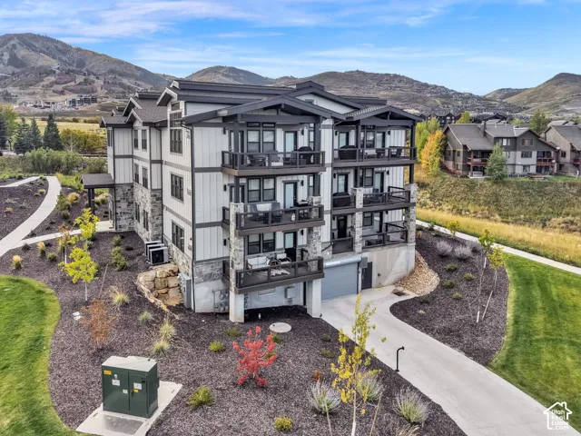 Multi-story building featuring stacked balconies, stone veneer, and horizontal siding