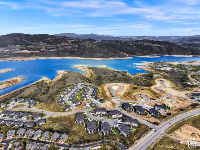 Expansive residential development with a large body of water, surrounded by rolling hills and distant mountains
