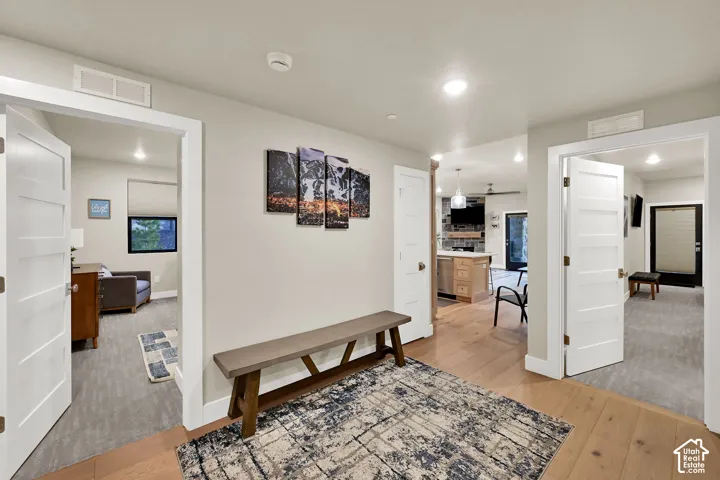 Hardwood-finish flooring, recessed lighting, and white interior doors