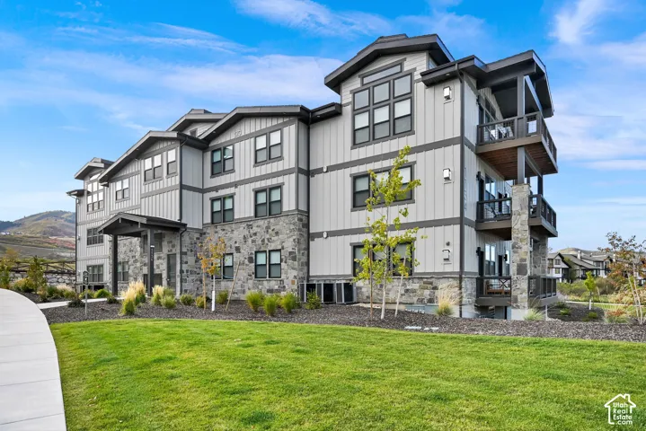 Contemporary multi-story building featuring stone veneer and vertical siding accents