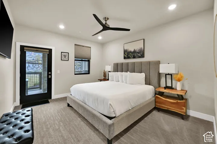 Recessed ceiling lighting, ceiling fan, carpet flooring, exterior door with glass panel, and window with roller shade
