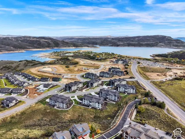 Residential development with multiple buildings featuring dark grey roofs, surrounded by paved roads and landscaping