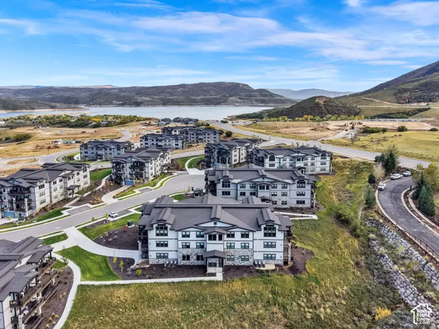 Expansive residential community featuring contemporary multi-unit architecture with modern facades, manicured landscaping, and curved access roads