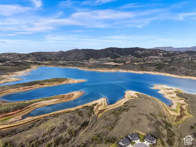 Expansive lake with surrounding land formations, complemented by distant mountainous terrain