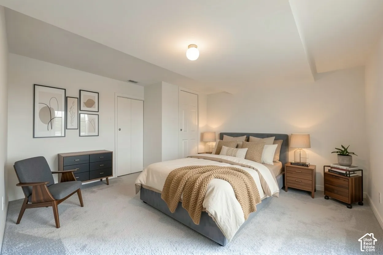 Light gray wall-to-wall carpeting, white walls, two integrated closets with bi-fold doors, and a ceiling-mounted light fixture