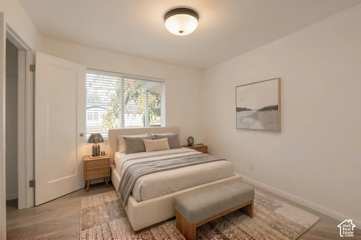 Recessed window with blinds, wood-finish flooring, and a flush-mount ceiling light fixture
