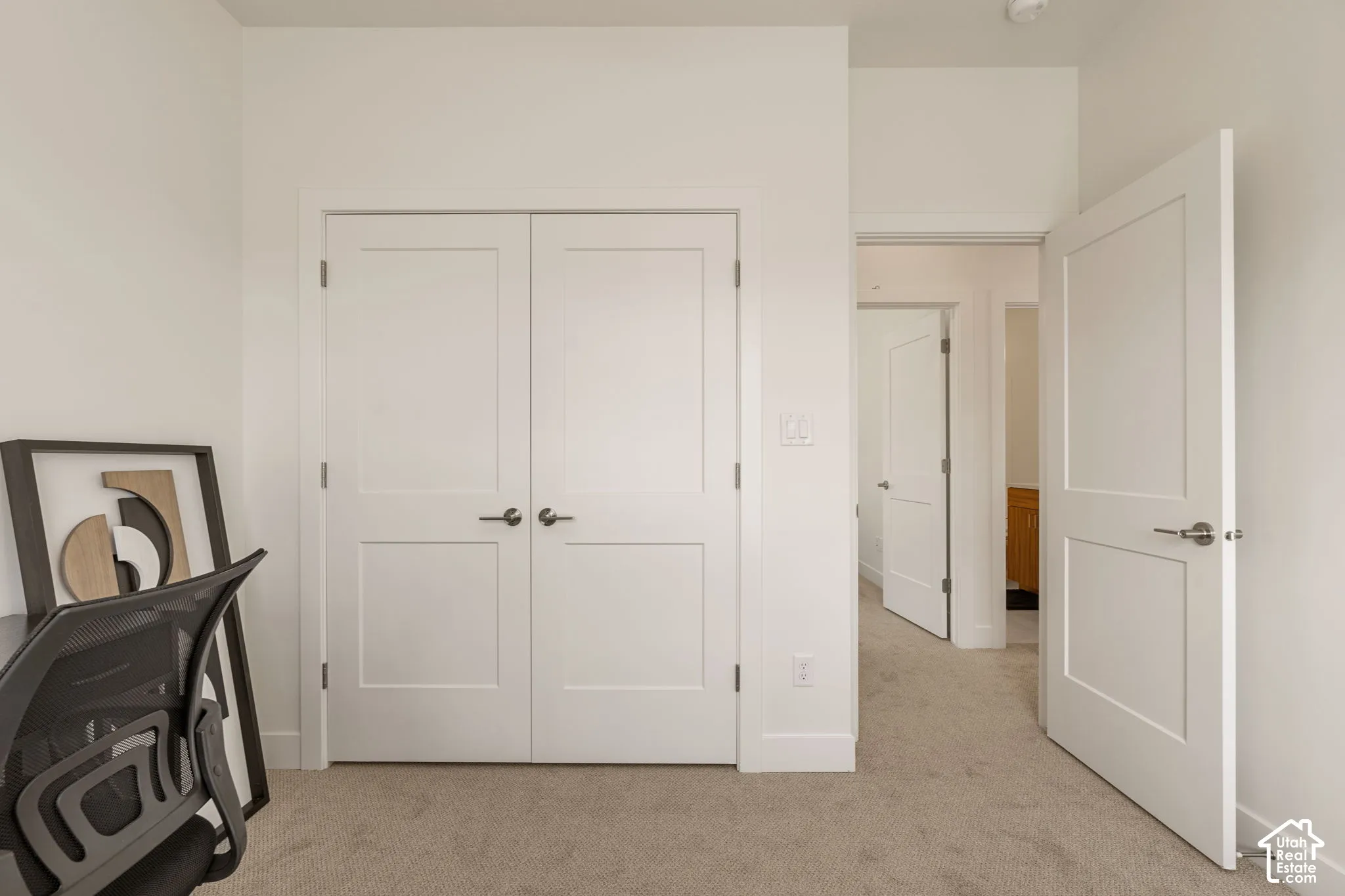 Spacious bedroom retreat featuring dual white panel closets with six-panel doors, neutral carpet flooring, and abundant natural light from multiple windows