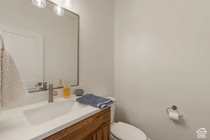 Solid surface countertop with integrated rectangular sink, single-handle faucet, wood-finish vanity, and wall-mounted mirror