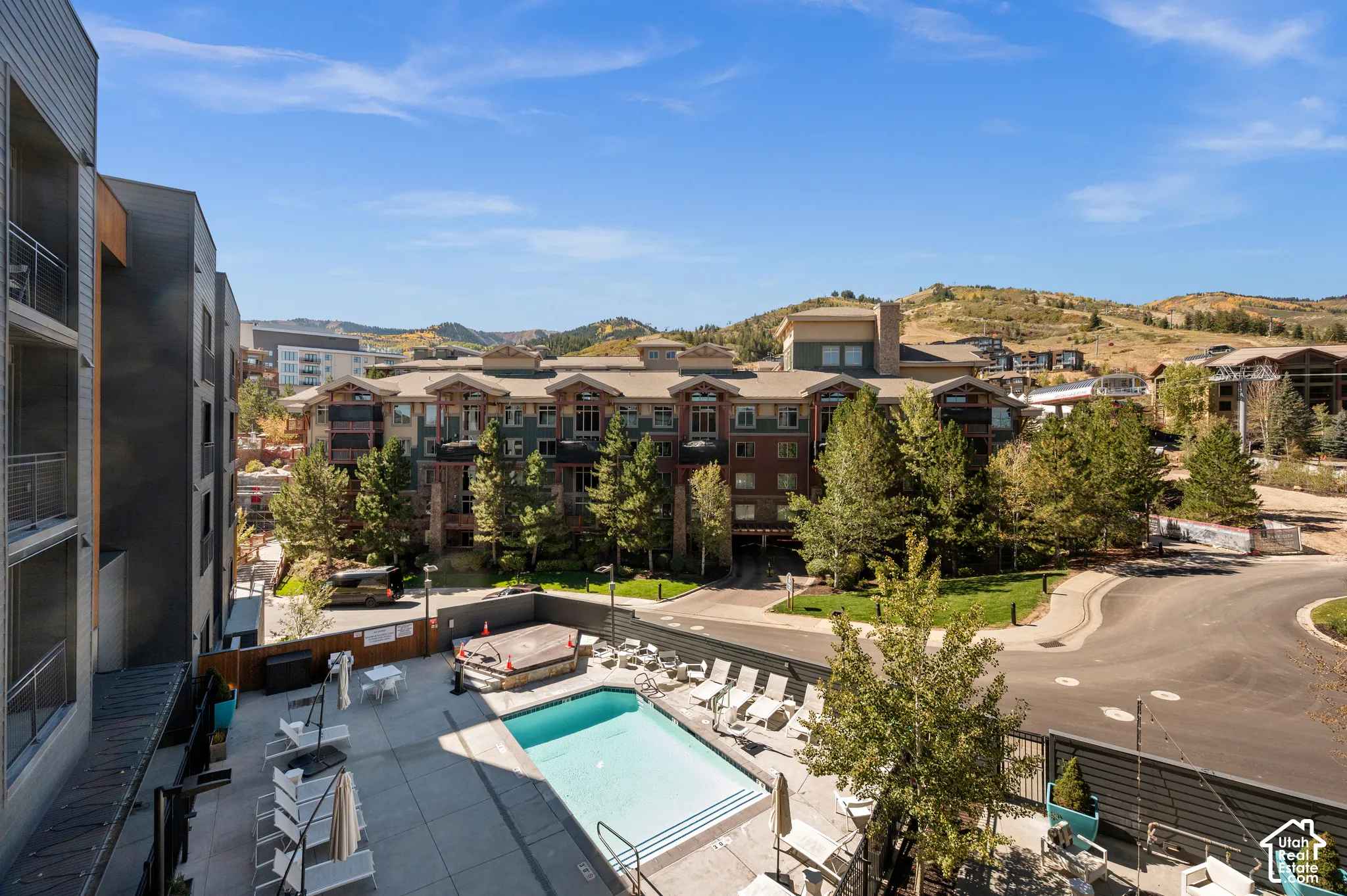 Outdoor pool with a hot tub, surrounded by a paved patio