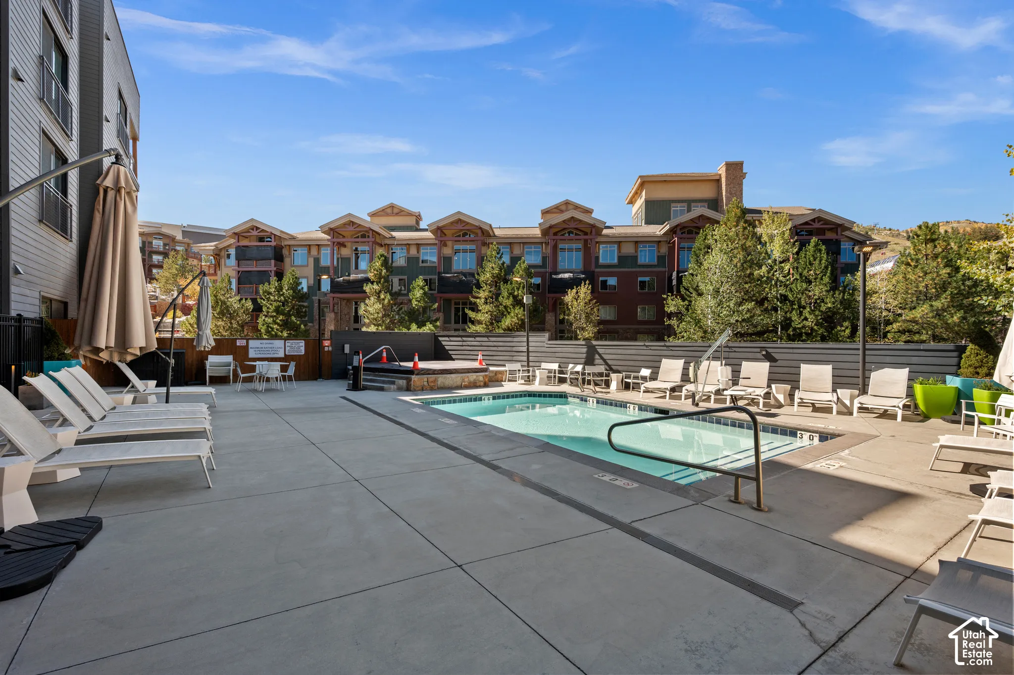 Outdoor swimming pool with integrated spa and concrete surround