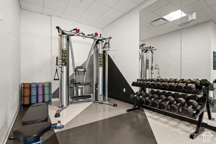 Fitness room with patterned flooring, mirrored wall, and overhead lighting