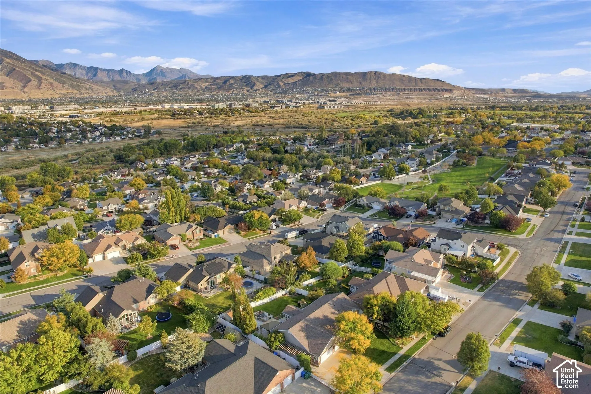 Aerial view showcasing a well-established residential community nestled against dramatic mountain backdrop