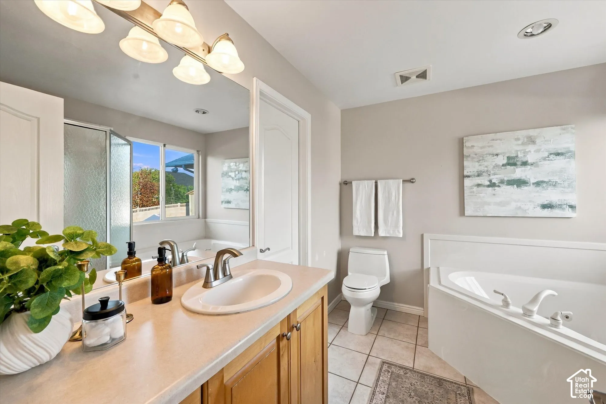 Spa-inspired primary bathroom featuring a wood-finish vanity with dual-basin sink, quartz countertop, and brushed nickel faucetry