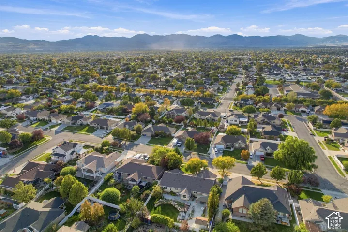 Aerial perspective showcasing a tree-lined residential community with mature landscaping, established neighborhoods, and mountain backdrop