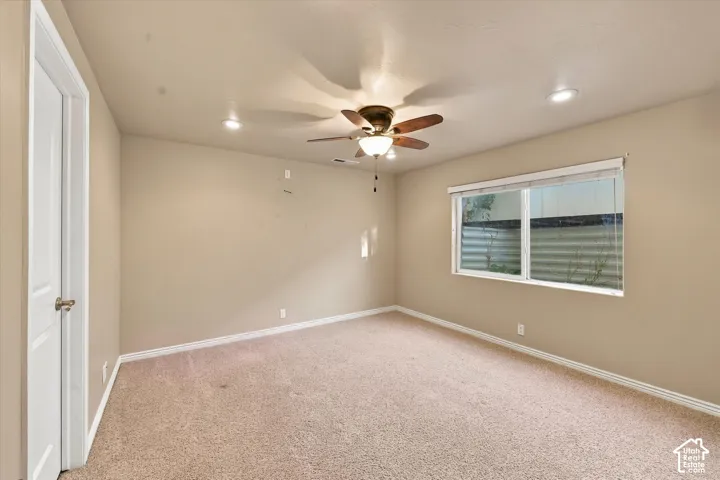 Recessed lighting, ceiling fan with light fixture, single window with blinds, and neutral carpet flooring