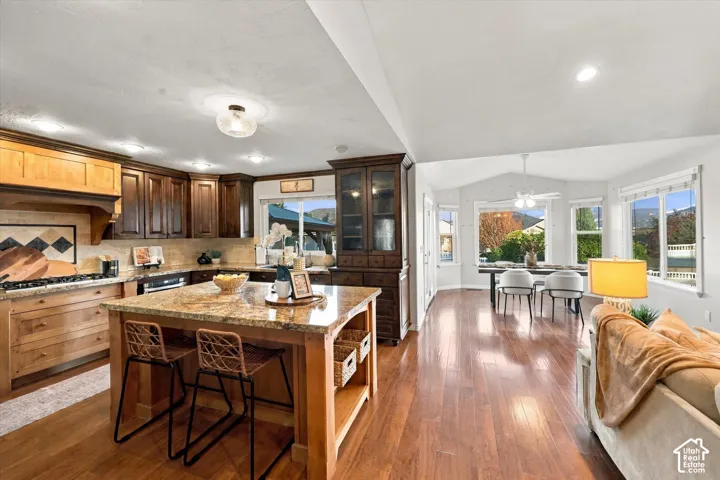 Kitchen featuring wood cabinetry, granite countertops, and a central island