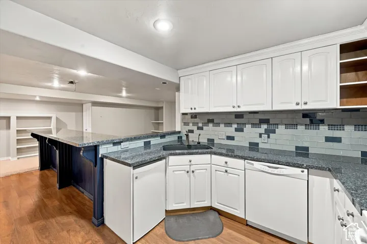 Contemporary kitchen featuring white cabinetry, stainless steel appliances, and a multi-toned subway tile backsplash
