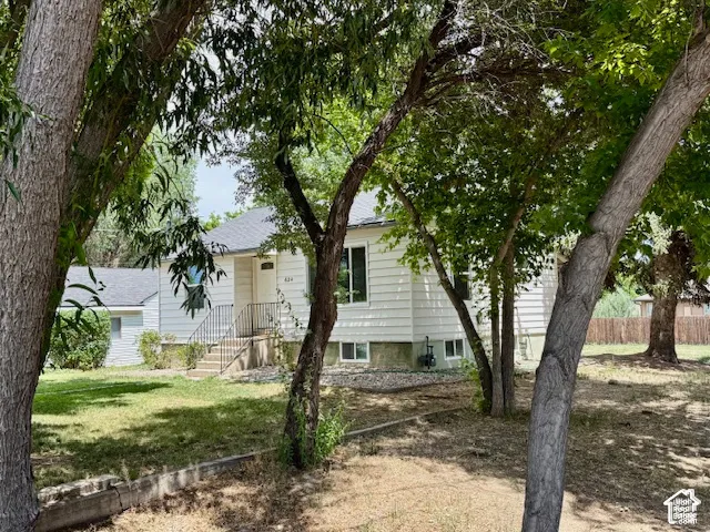 Charming residence nestled among mature shade trees offering a serene, tree-lined setting