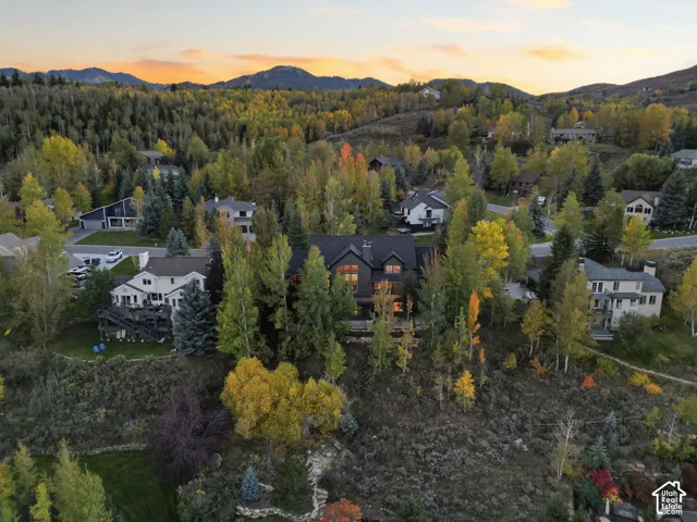 Mountainous background with a neighborhood of residential properties, surrounded by mature trees