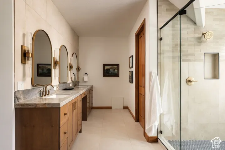 Expansive vanity with integrated sinks, brass-finish fixtures, and arched mirrors