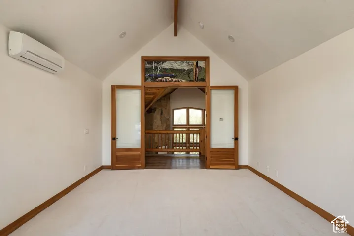 Vaulted ceiling, recessed lighting, split mini-AC unit, wood-finish doors with frosted glass panels, and a wood-finish railing