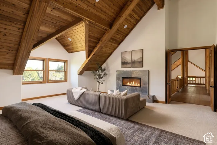 Vaulted wood-paneled ceilings with exposed beams, dual windows, and a built-in fireplace with a stone surround