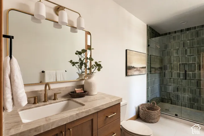 Modern bathroom featuring a wood-finish vanity with a rectangular undermount sink, a countertop, and a walk-in shower with green tile and a built-in bench