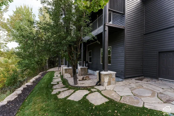Dark horizontal siding with an upper-level balcony featuring vertical metal railings