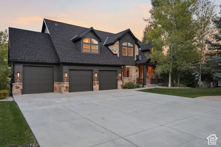 Stone and siding exterior with dark shingles