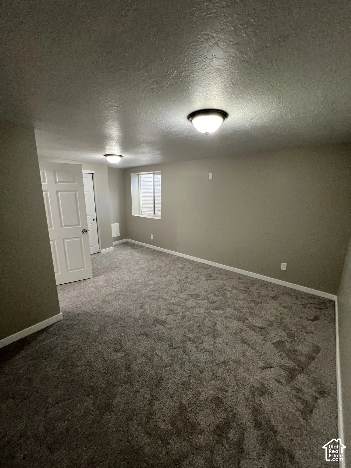 Recessed window with horizontal blinds, neutral wall tones, and gray carpeting