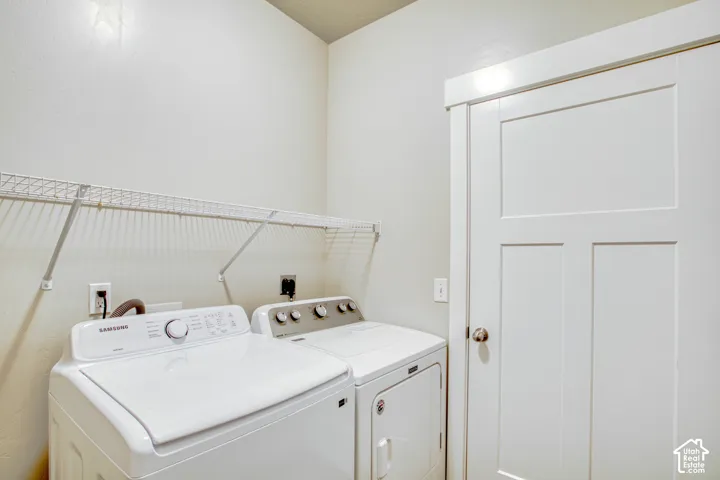 Laundry area featuring a wire shelf, white interior door with paneling, and a satin nickel doorknob