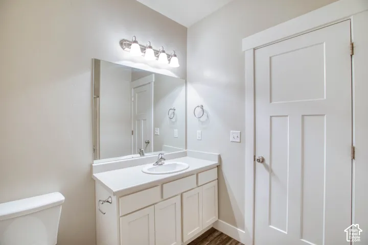 White vanity with an integrated sink, brushed nickel faucet, and a large wall-mounted mirror