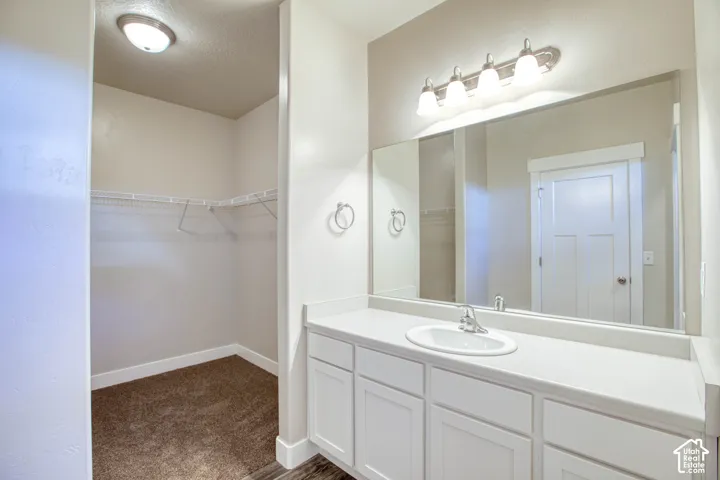 White vanity with an integrated sink, polished chrome faucet, and a large mirror