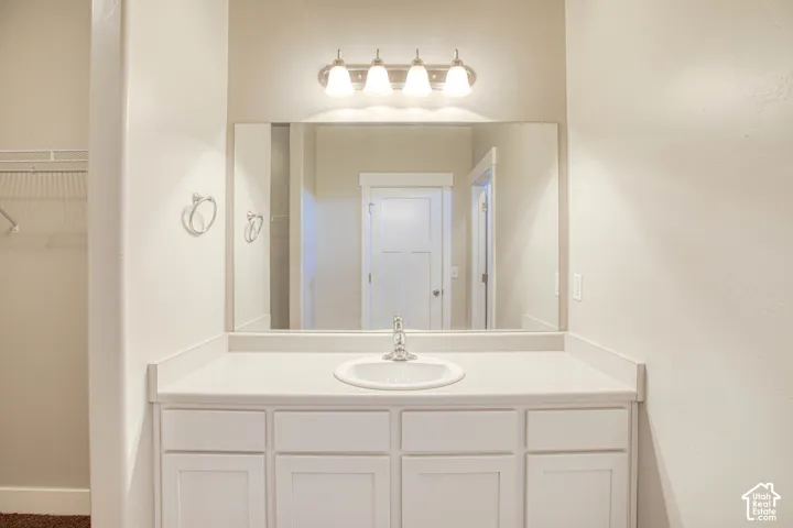 Vanity featuring a single-bowl sink, chrome faucet, and integrated counter space