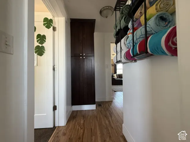 Wood-finish flooring throughout, complemented by a tall built-in dark wood cabinet