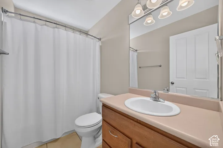 Bathroom with a curved shower rod, vanity with a laminate countertop, and an integrated basin