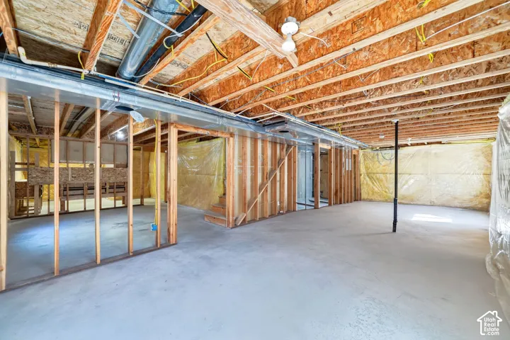 Spacious unfinished interior with exposed wood-frame construction, concrete flooring, and industrial ceiling with ductwork and mechanical systems