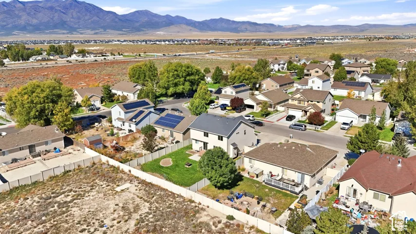 Aerial view of a residential neighborhood featuring well-appointed homes with varied architectural styles, mature landscaping throughout the community, and mountain vistas in the distance