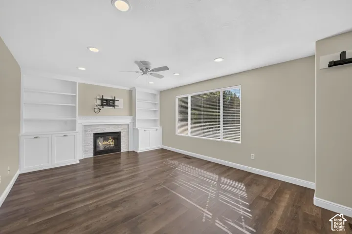 Spacious room featuring wood-finish flooring, recessed lighting, and a ceiling fan