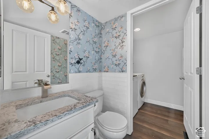 Vanity with a rectangular sink and stone countertop, complemented by a decorative mirror and wall-mounted light fixture