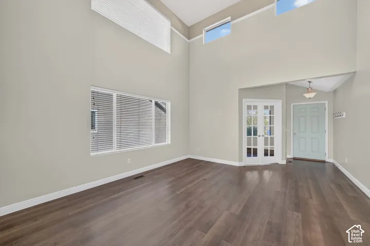 Bright, open living space featuring soaring vaulted ceilings with skylights, wood-finish flooring throughout, and clerestory windows