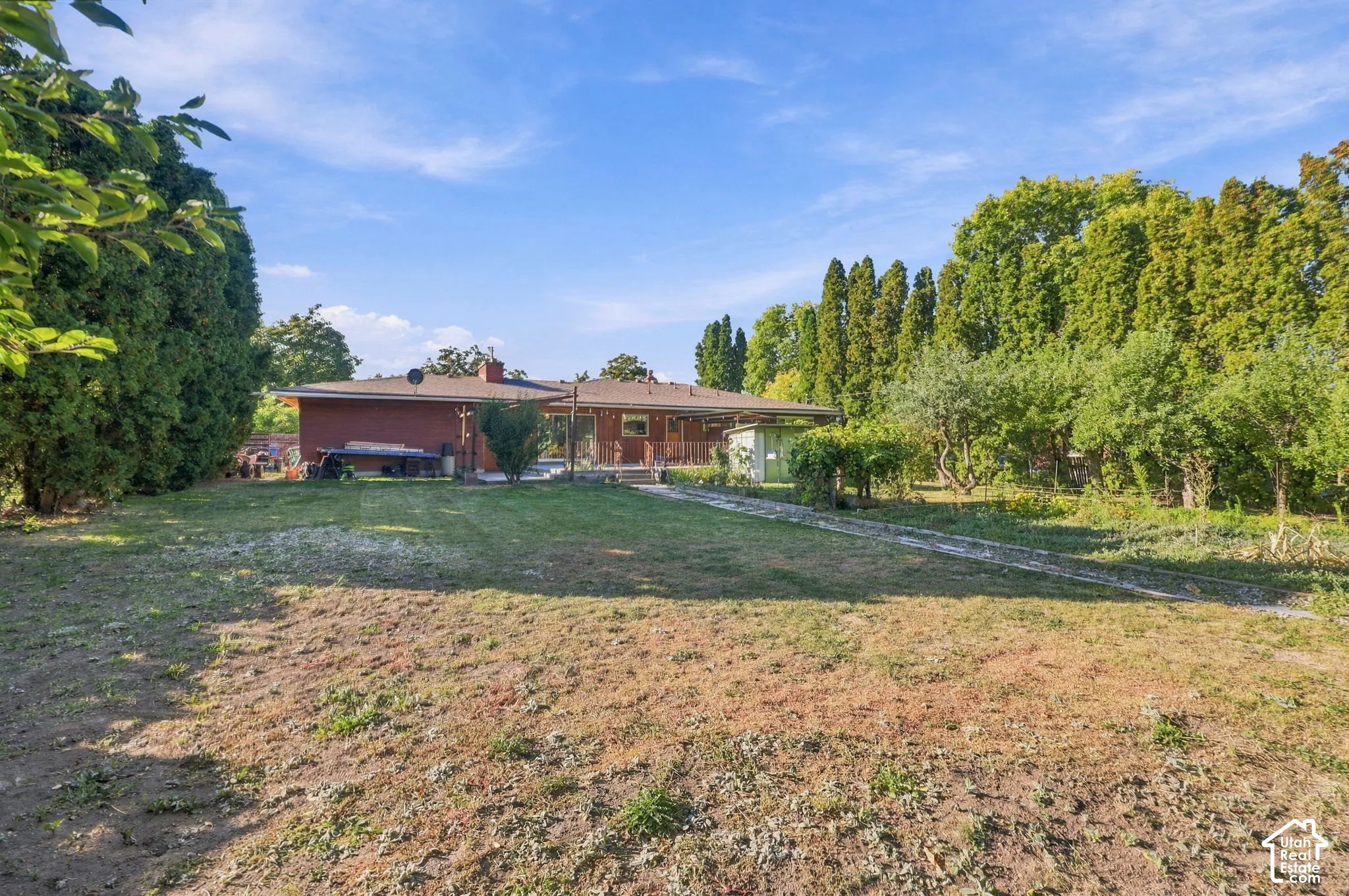 Expansive grounds featuring mature landscaping, manicured lawn, and established tree line